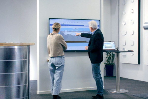 People watching a big TV screen in the showroom in Farum. One of them is explaining air diffusion on the screan with the help of smoke simulation in indoor climate designer / lindqst People watching a big TV screen in the showroom in Farum. One of them is explaining air diffusion on the screan with the help of smoke simulation in indoor climate designer / lindqst